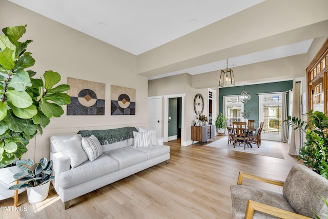 living room with light wood-style floors and a chandelier