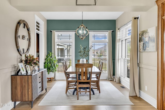 dining area featuring a notable chandelier and light wood-type flooring