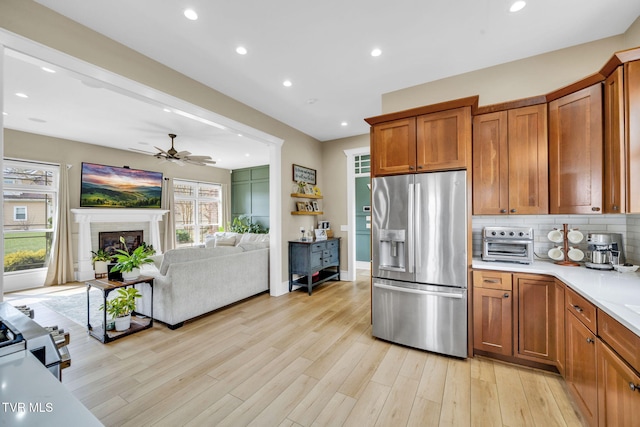 kitchen featuring stainless steel fridge, tasteful backsplash, and brown cabinetry