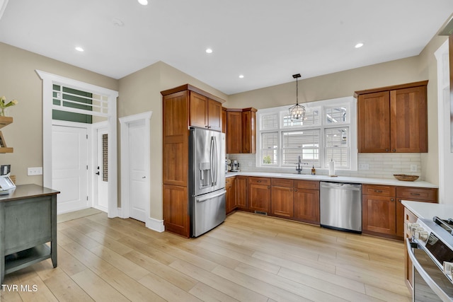 kitchen featuring light wood-style flooring, brown cabinetry, and stainless steel appliances