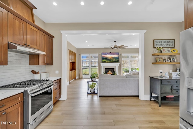 kitchen with under cabinet range hood, light wood-style floors, appliances with stainless steel finishes, and ceiling fan