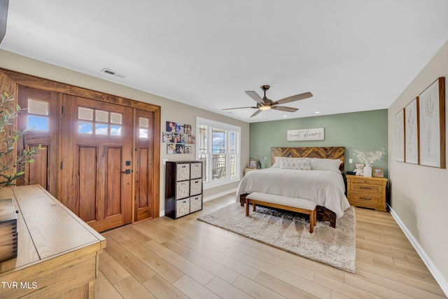 bedroom featuring visible vents, baseboards, and light wood finished floors