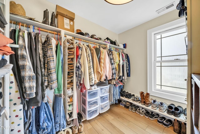 walk in closet with hardwood / wood-style floors and visible vents