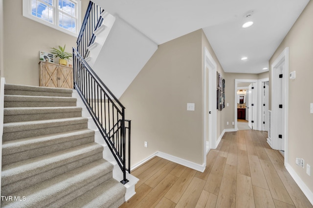 stairway featuring recessed lighting, baseboards, and wood finished floors