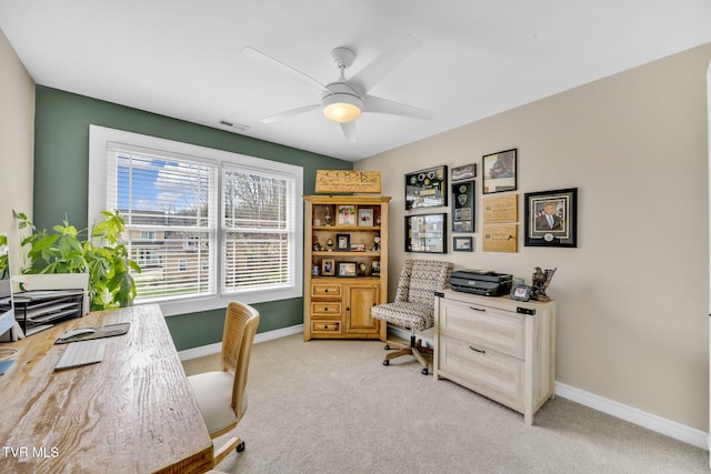 office space with visible vents, light colored carpet, baseboards, and ceiling fan