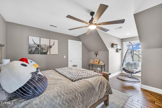 bedroom featuring visible vents, lofted ceiling, baseboards, and wood-type flooring