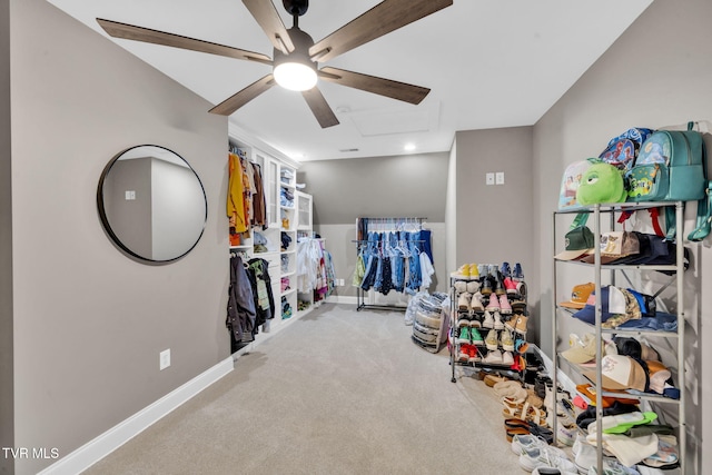 interior space featuring baseboards, a ceiling fan, attic access, and carpet flooring