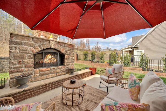 view of patio featuring an outdoor living space with a fireplace and fence