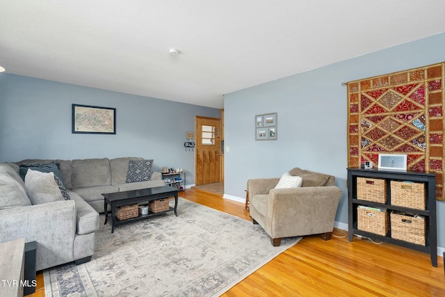 living area featuring light wood finished floors and baseboards