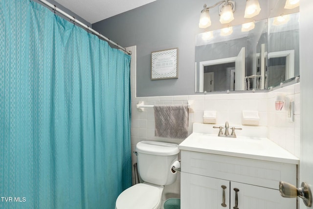 bathroom featuring toilet, tile walls, and vanity