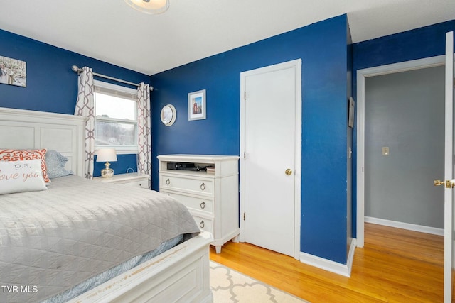 bedroom with baseboards and light wood finished floors