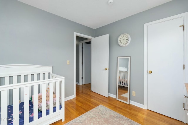 bedroom featuring baseboards and light wood finished floors