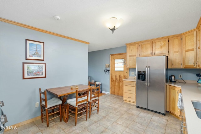 kitchen with baseboards, light countertops, and stainless steel refrigerator with ice dispenser