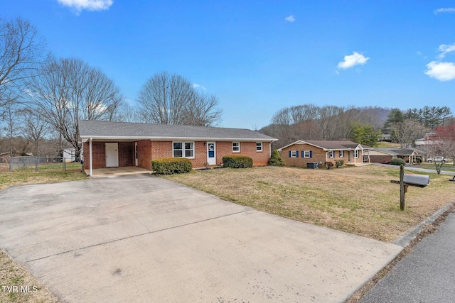 single story home with driveway, a front lawn, an attached carport, fence, and brick siding