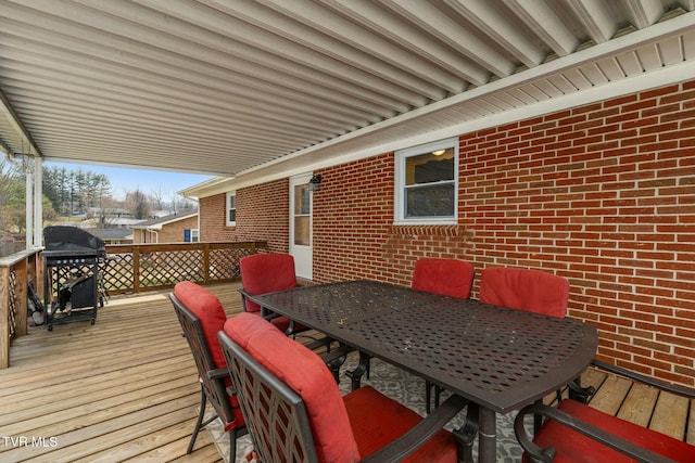 deck with outdoor dining space and a grill