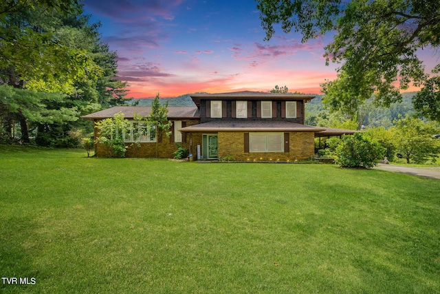 split level home with a lawn, brick siding, and driveway