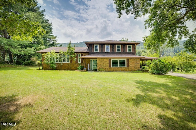 split level home featuring brick siding, an attached carport, driveway, and a front yard