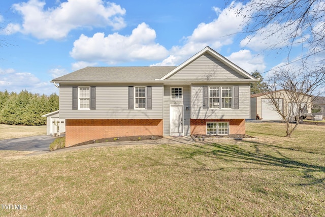 bi-level home featuring brick siding, an outdoor structure, and a front lawn