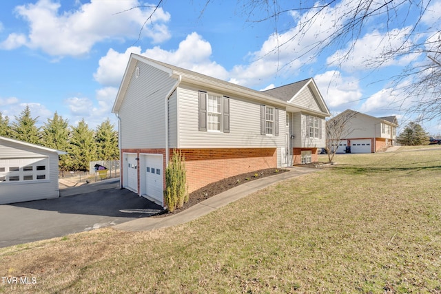 view of property exterior featuring brick siding, a lawn, an attached garage, and driveway