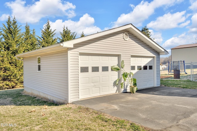 detached garage featuring fence