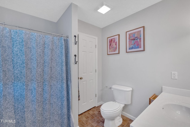 full bath with a shower with shower curtain, baseboards, a sink, a textured ceiling, and toilet