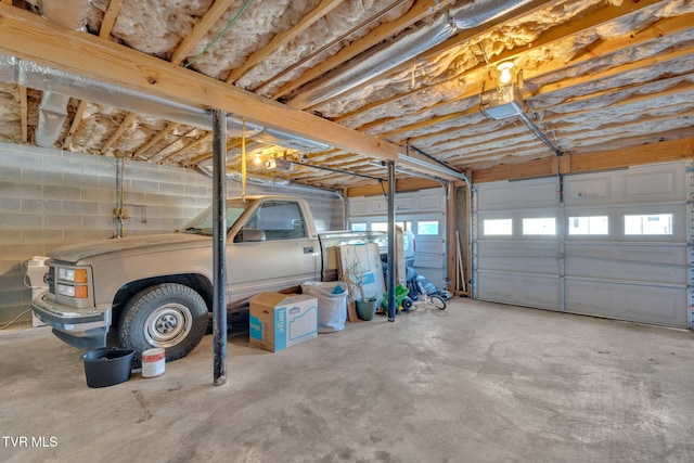 garage with concrete block wall and a garage door opener