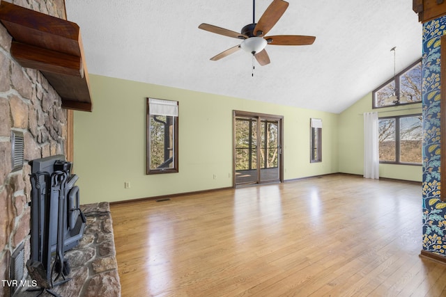 unfurnished living room featuring baseboards, wood finished floors, a textured ceiling, high vaulted ceiling, and a ceiling fan