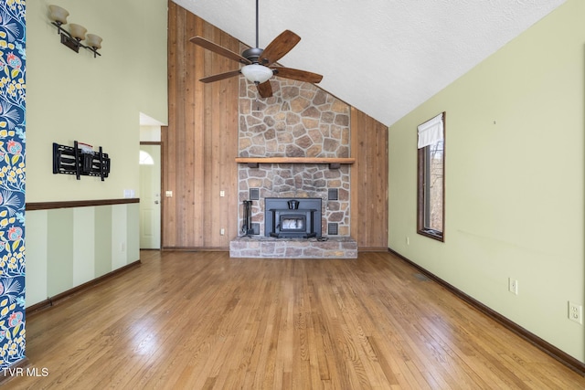 unfurnished living room with ceiling fan, baseboards, a textured ceiling, high vaulted ceiling, and wood-type flooring