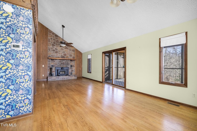 unfurnished living room featuring a wealth of natural light, visible vents, lofted ceiling, and wood finished floors