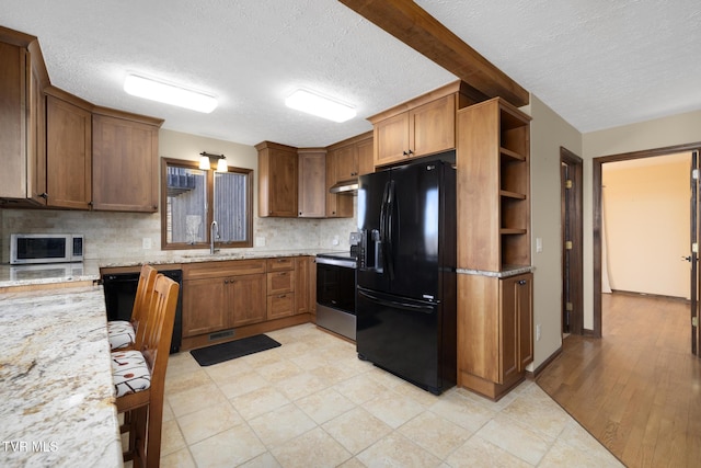 kitchen with black fridge, a sink, open shelves, tasteful backsplash, and stainless steel electric range