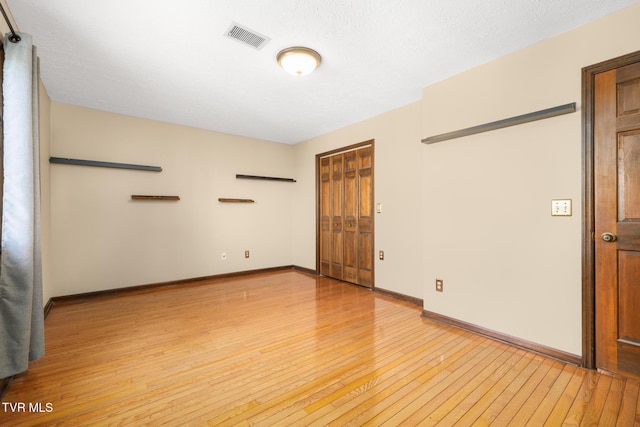 unfurnished room with visible vents, baseboards, and light wood-style floors