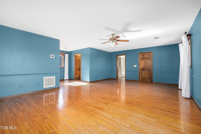 unfurnished living room with visible vents, ceiling fan, baseboards, and light wood-style floors