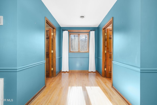 corridor with wood finished floors and visible vents