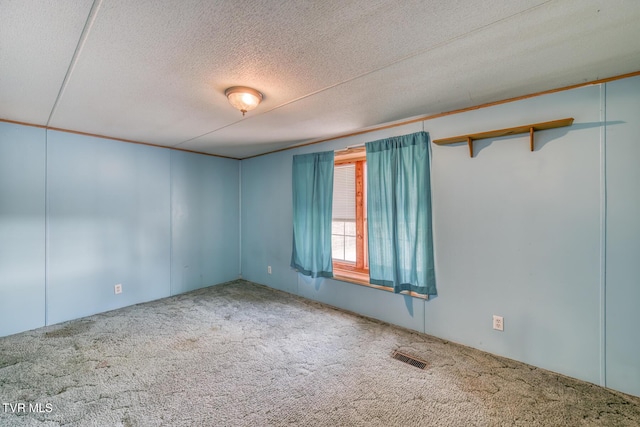 spare room with visible vents, carpet floors, and a textured ceiling