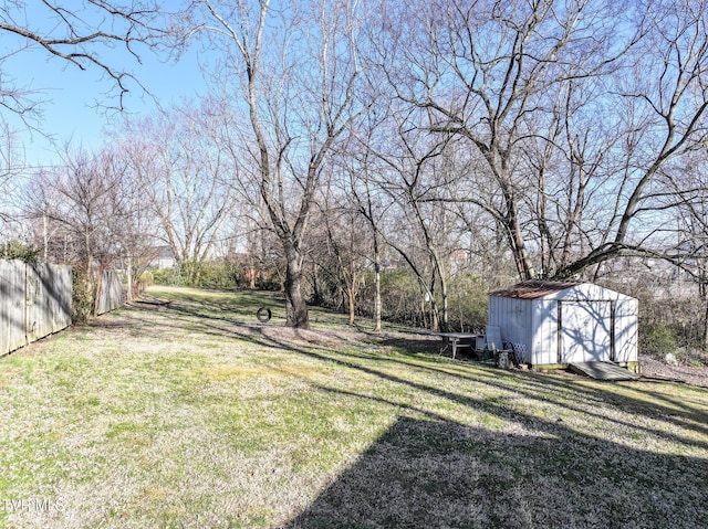 view of yard with a storage unit, an outbuilding, and fence