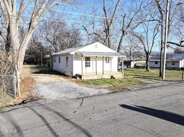 view of front of home with metal roof, covered porch, and driveway