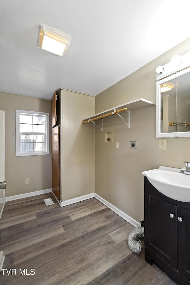 washroom featuring washer hookup, wood finished floors, a sink, and electric dryer hookup