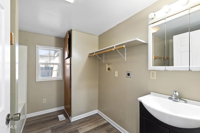 laundry area featuring electric dryer hookup, dark wood-type flooring, baseboards, hookup for a washing machine, and laundry area