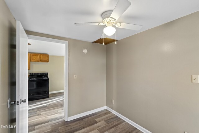 spare room with ceiling fan, baseboards, and wood finished floors