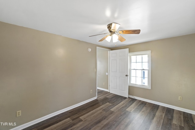 spare room featuring dark wood-type flooring, baseboards, and ceiling fan