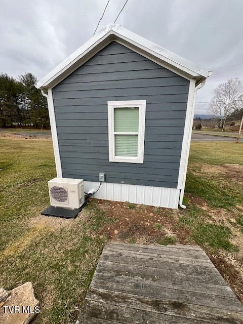 view of home's exterior featuring ac unit, a yard, and an outbuilding