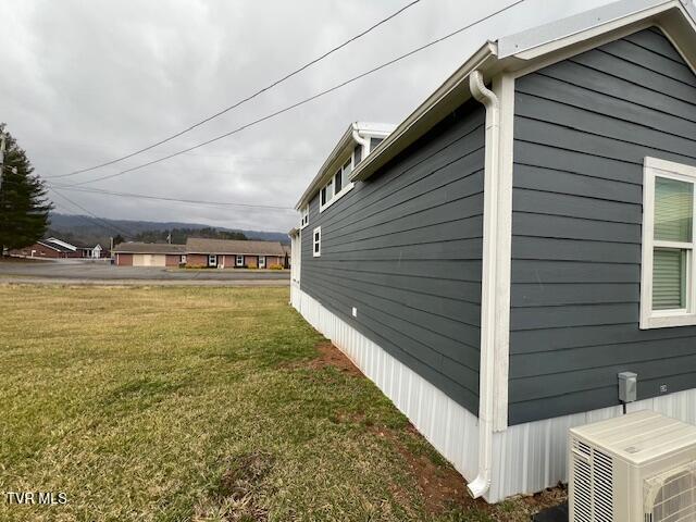 view of home's exterior with ac unit and a lawn