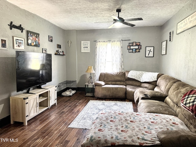 living room featuring baseboards, dark wood finished floors, ceiling fan, a textured ceiling, and a textured wall