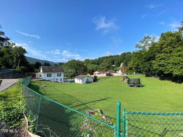 view of yard featuring a playground, fence, and a mountain view