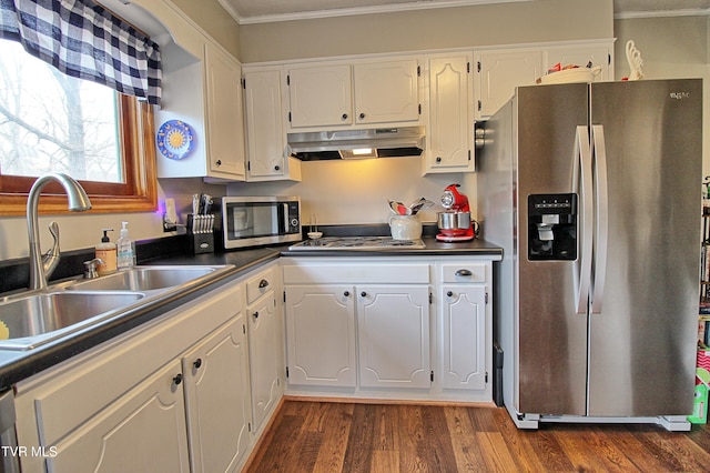 kitchen with under cabinet range hood, stainless steel appliances, dark countertops, and a sink