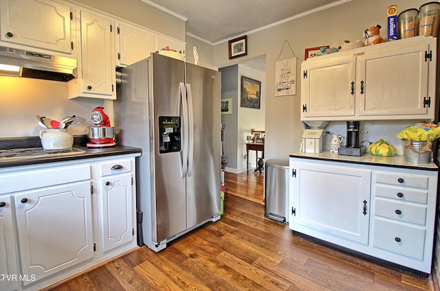 kitchen featuring dark countertops, crown molding, under cabinet range hood, appliances with stainless steel finishes, and dark wood-style floors