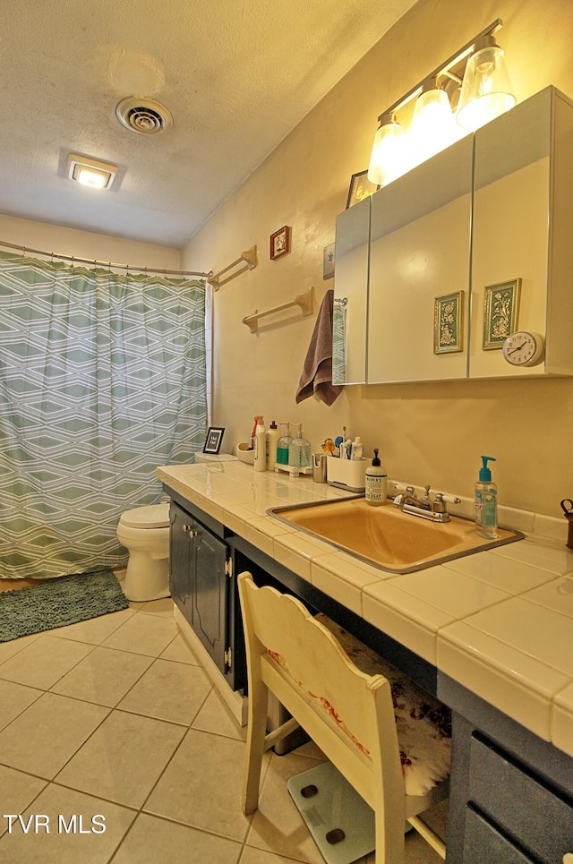 bathroom featuring vanity, visible vents, tile patterned flooring, a textured ceiling, and toilet