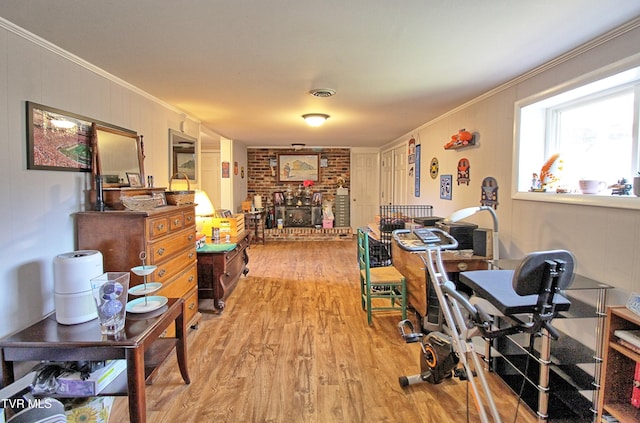 office featuring visible vents, a fireplace, light wood-style floors, and ornamental molding