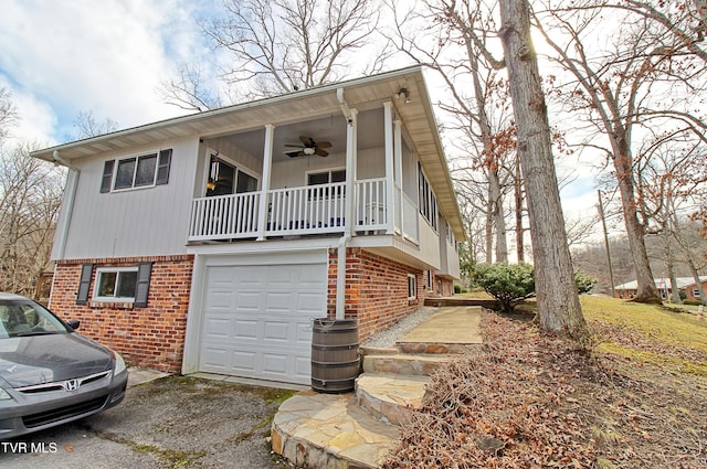 view of front of property with brick siding, driveway, an attached garage, and ceiling fan