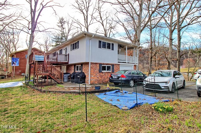 view of property exterior featuring brick siding, stairway, a lawn, and driveway